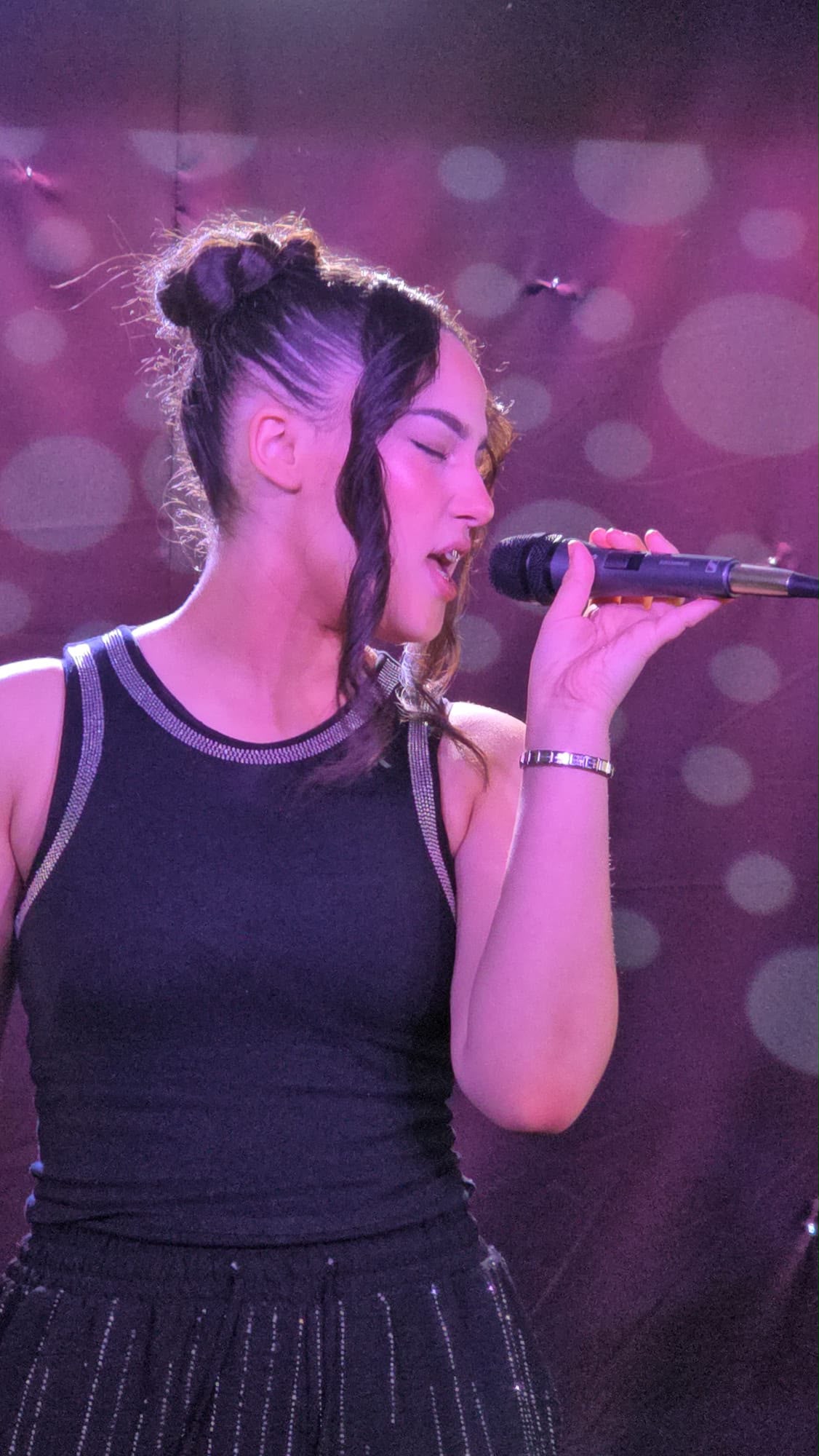 Ella-Grace singing into a microphone